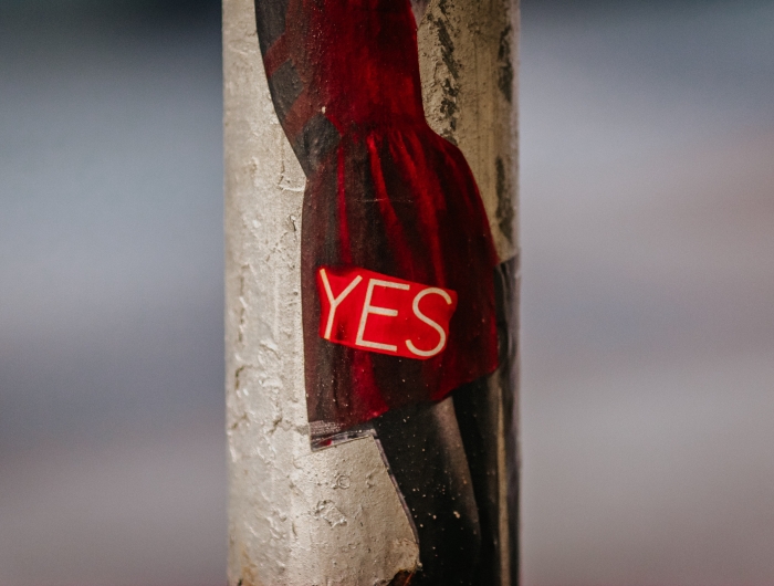 A sticker of the word YES on a lamp post