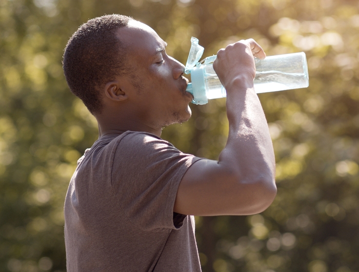 man drinking water from a reusable water bottle