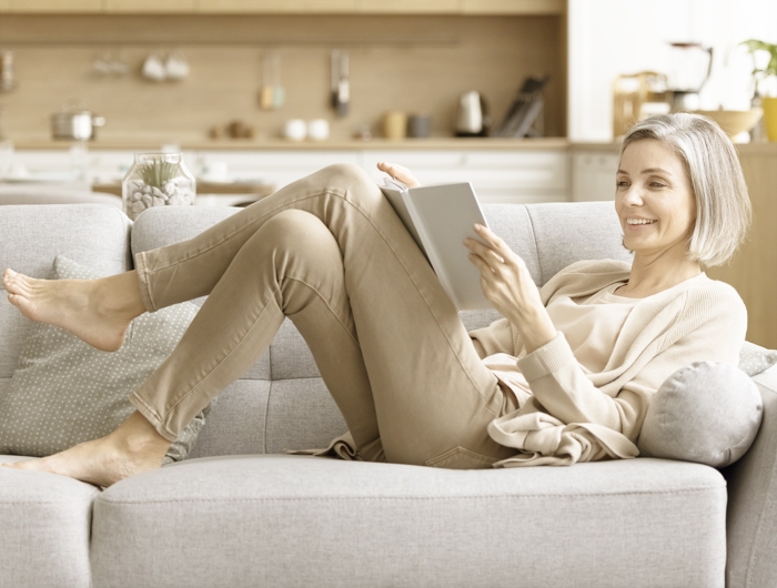 woman lounging and reading on a couch