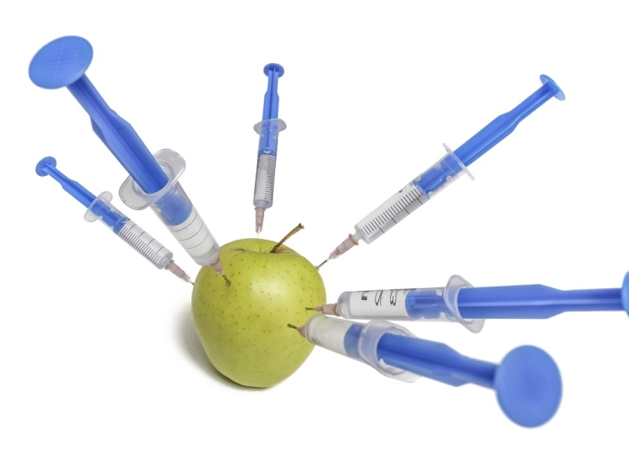 Graphic of an apple being injected by several syringes.