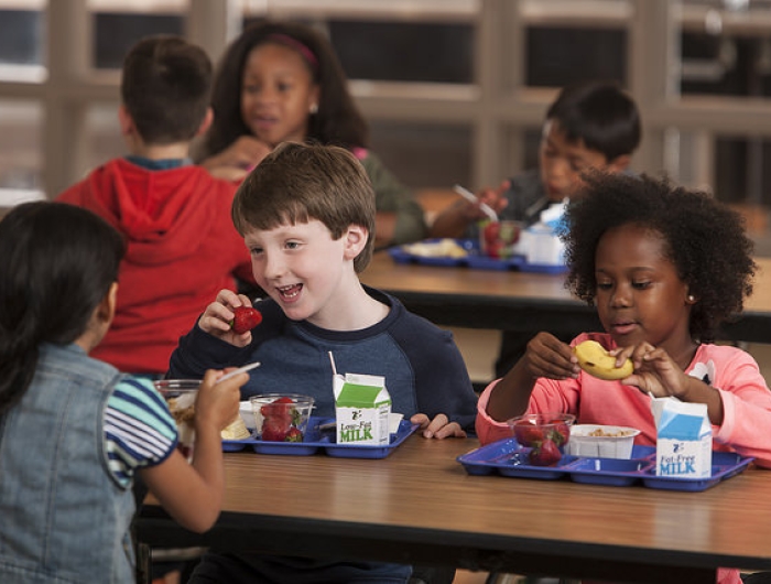 Children eating healthy foods in a school cafeteria