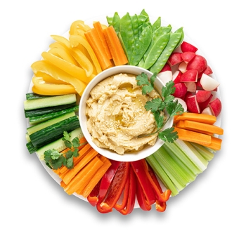 vegetable platter with various sliced vegetables and dip in the middle