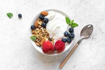 bowl filled with yogurt, berries, seeds and nuts