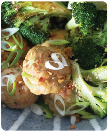 close up of broccoli and poultry meatballs with spices
