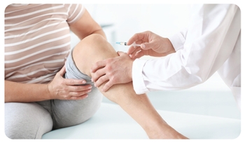 doctor giving a patient an injection in their knee